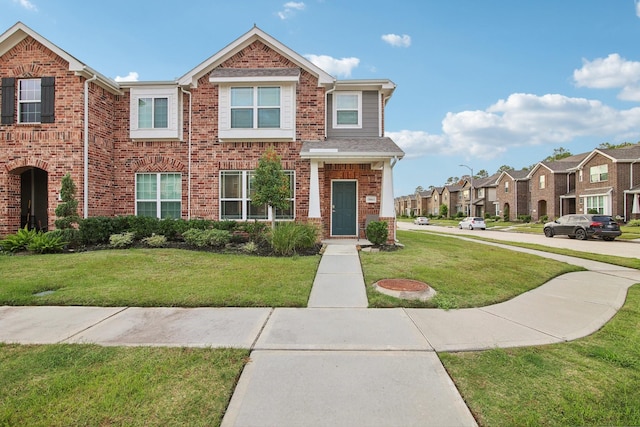 15863 Sundew Prairie Dr, Humble, TX 77346 - view of property featuring a front yard, brick siding, and a residential view