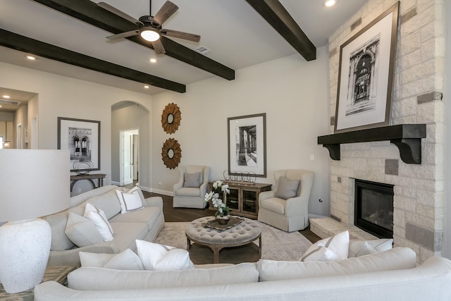 17016 Sweet Iris Ct, Conroe, TX 77302 - living room with beam ceiling, arched walkways, ceiling fan, a fireplace, and wood finished floors