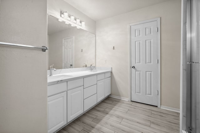 8006 Saffron Ln, Baytown, TX 77521 - full bath featuring double vanity, baseboards, and wood finished floors