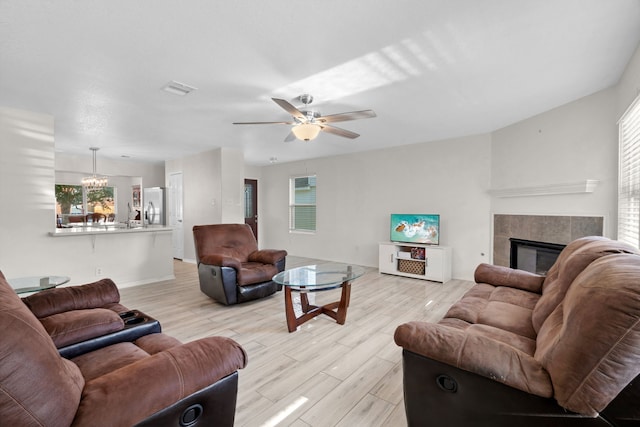 8006 Saffron Ln, Baytown, TX 77521 - living room with light wood-style floors, a ceiling fan, a fireplace, and baseboards