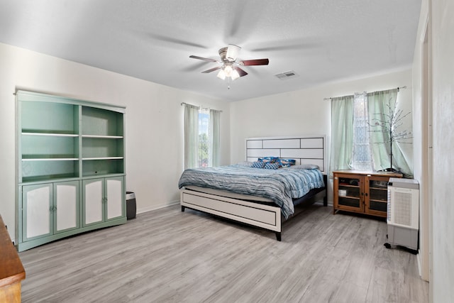 8006 Saffron Ln, Baytown, TX 77521 - bedroom featuring wood finished floors, baseboards, a ceiling fan, and a textured ceiling