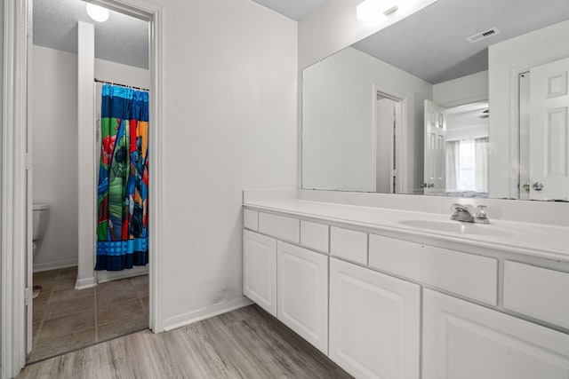 8006 Saffron Ln, Baytown, TX 77521 - bathroom featuring vanity, baseboards, toilet, and wood finished floors