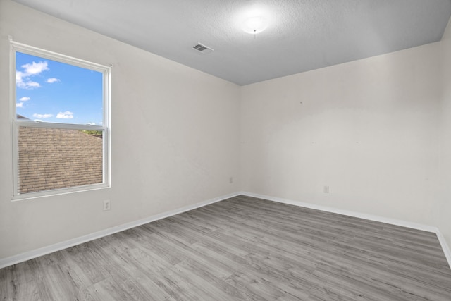 8006 Saffron Ln, Baytown, TX 77521 - spare room with wood finished floors, baseboards, and a textured ceiling