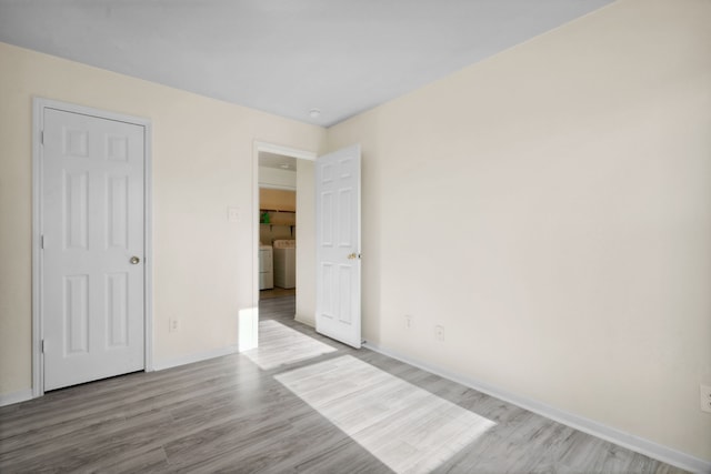 8006 Saffron Ln, Baytown, TX 77521 - unfurnished bedroom with washer and dryer, wood finished floors, and baseboards