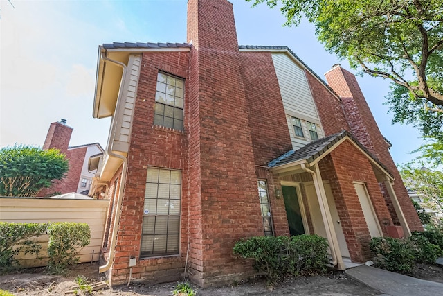 2211 S Kirkwood Rd Unit 19, Houston, TX 77077 - view of property exterior with a chimney, fence, and brick siding