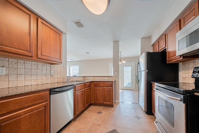 2211 S Kirkwood Rd Unit 19, Houston, TX 77077 - kitchen featuring stainless steel appliances, brown cabinets, a sink, and light tile patterned flooring