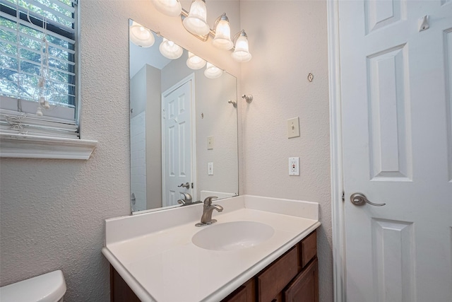 2211 S Kirkwood Rd Unit 19, Houston, TX 77077 - bathroom with toilet, vanity, and a textured wall