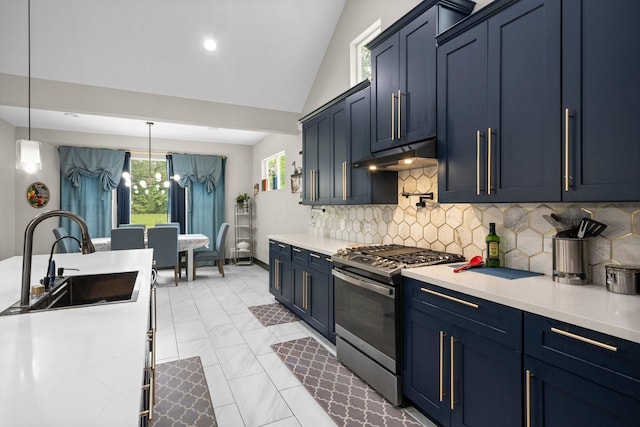 16709 W Rayburn Dr, Conroe, TX 77302 - kitchen with gas stove, a sink, blue cabinetry, under cabinet range hood, and backsplash