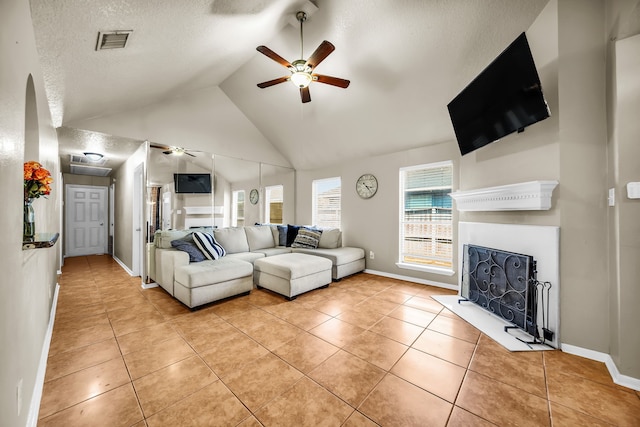 15153 Grassington Dr, Channelview, TX 77530 - living room with ceiling fan, baseboards, a fireplace, light tile patterned floors, and a textured ceiling