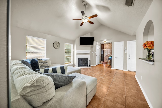 15153 Grassington Dr, Channelview, TX 77530 - living room featuring light tile patterned floors, a ceiling fan, lofted ceiling, a fireplace with flush hearth, and baseboards