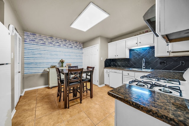 15153 Grassington Dr, Channelview, TX 77530 - kitchen with dishwasher, white cabinets, dark countertops, a sink, and light tile patterned floors