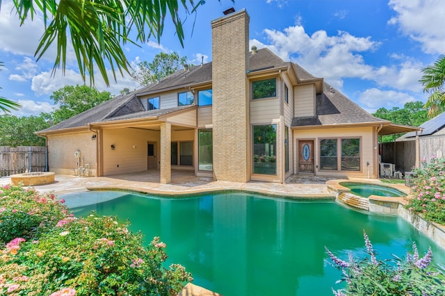 view of pool featuring a patio, fence, and a pool with connected hot tub