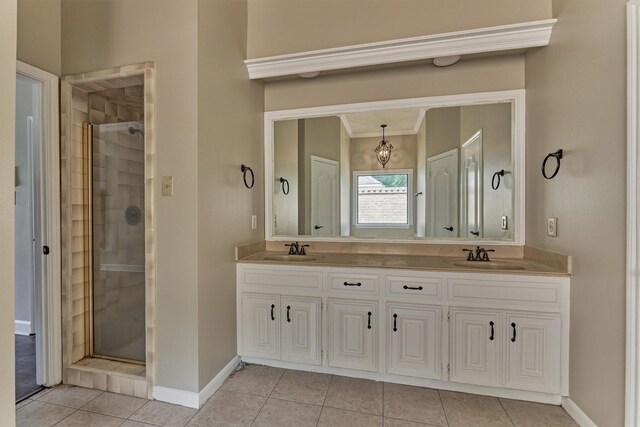 bathroom featuring a shower stall, tile patterned flooring, baseboards, double vanity, and crown molding
