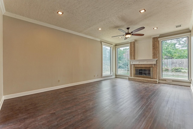 unfurnished living room with a textured ceiling, plenty of natural light, crown molding, dark wood-type flooring, and baseboards