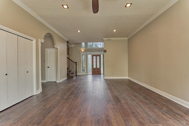 unfurnished living room featuring dark wood-style flooring, ceiling fan, stairway, a textured ceiling, and baseboards
