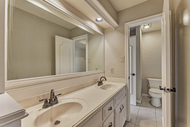 bathroom featuring toilet, tile patterned floors, and double vanity