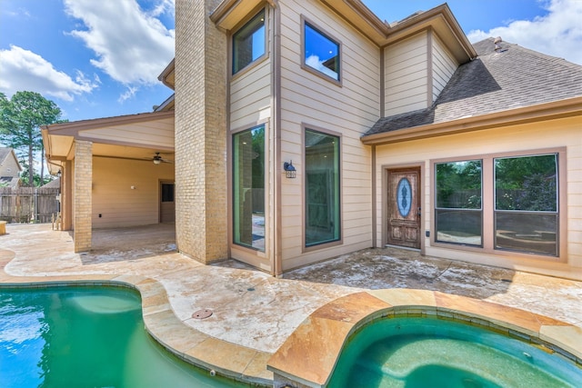 view of pool with a patio, a ceiling fan, fence, and an in-ground hot tub