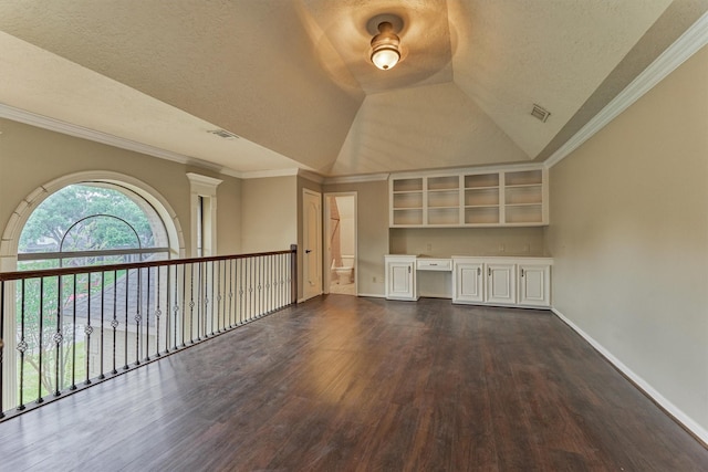 unfurnished room featuring dark wood-style floors, baseboards, a textured ceiling, vaulted ceiling, and crown molding