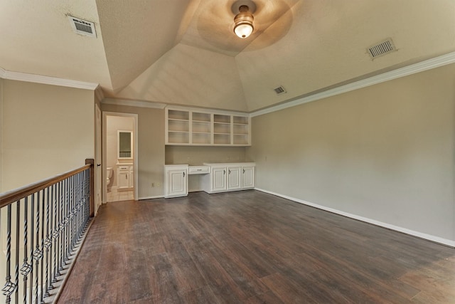unfurnished living room with dark wood-style floors, lofted ceiling, baseboards, and crown molding