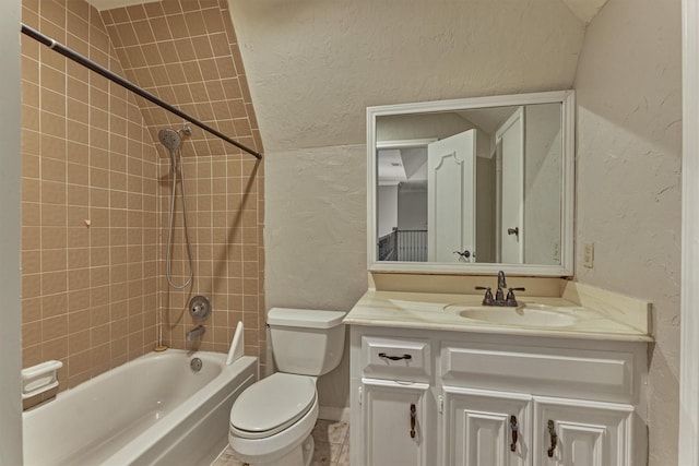 bathroom featuring a textured wall, shower / washtub combination, toilet, and vanity