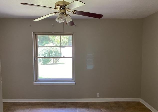 404 Friery St, Dayton, TX 77535 - spare room featuring healthy amount of natural light, baseboards, and ceiling fan