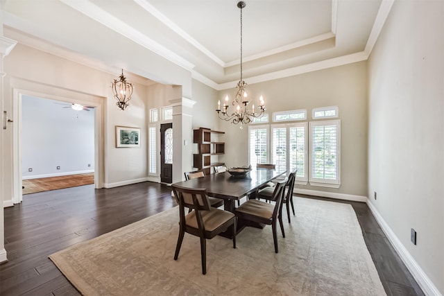 dining space featuring a chandelier, dark wood-style floors, ornamental molding, and a ceiling fan