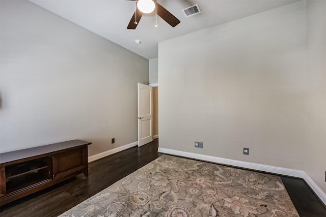 empty room featuring wood finished floors, baseboards, and a ceiling fan