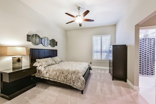 bedroom featuring baseboards, light carpet, ceiling fan, and lofted ceiling