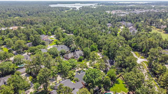 aerial overview of property's location featuring a forest and nearby suburban area