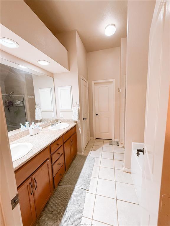 52 Fairway Dr, Normangee, TX 77871 - bathroom with a shower stall, tile patterned flooring, and double vanity