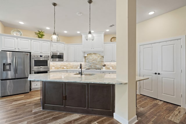 146 Painted Trillium Dr, Conroe, TX 77304 - kitchen featuring stainless steel appliances, a sink, white cabinetry, decorative backsplash, and dark wood-style floors