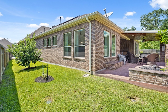 146 Painted Trillium Dr, Conroe, TX 77304 - view of side of home featuring ceiling fan, brick siding, a fire pit, and a patio