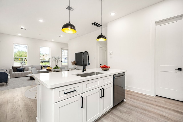 747 Dumble St, Houston, TX 77023 - kitchen featuring dishwasher, a sink, light wood-type flooring, hanging light fixtures, and light countertops