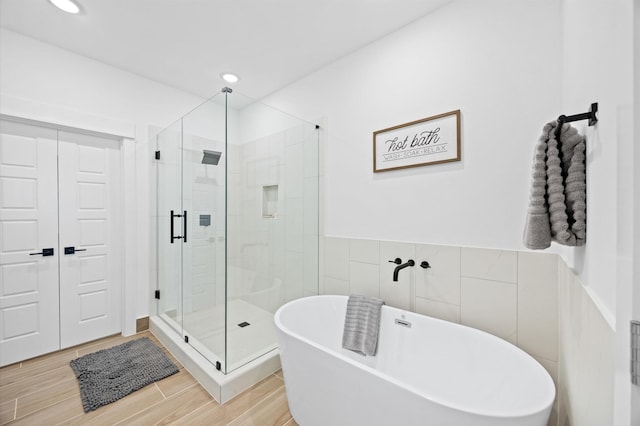 5814 Highland Sky Ln, Houston, TX 77091 - full bath with a soaking tub, a stall shower, tile walls, wood finished floors, and recessed lighting