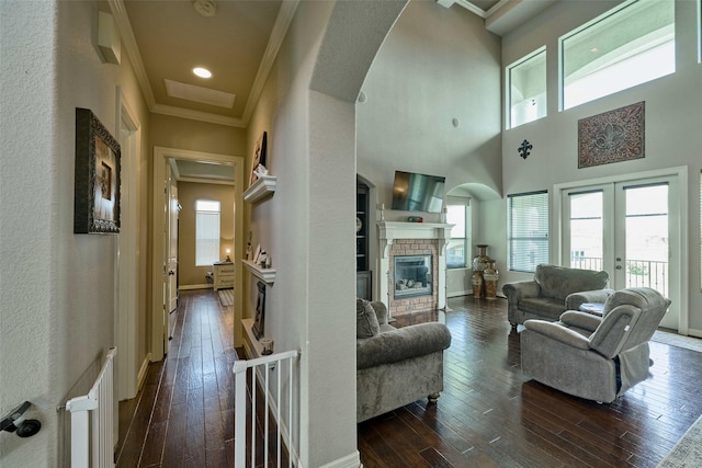 12590 St Ann Ct, Willis, TX 77318 - living area featuring a stone fireplace, arched walkways, healthy amount of natural light, and crown molding