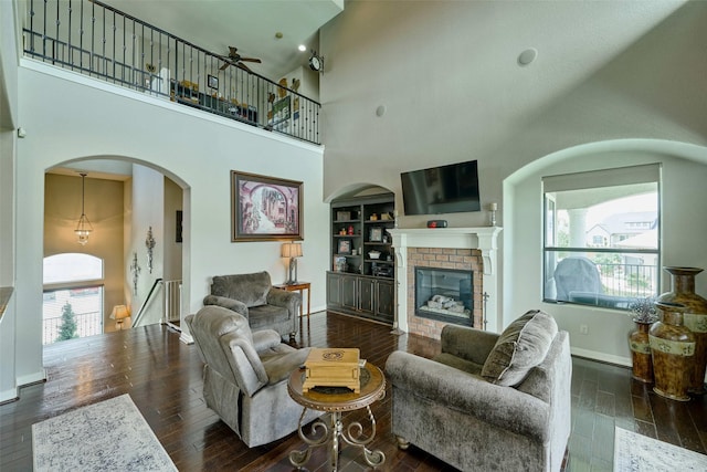 12590 St Ann Ct, Willis, TX 77318 - living area with wood finished floors, ceiling fan, a towering ceiling, and baseboards