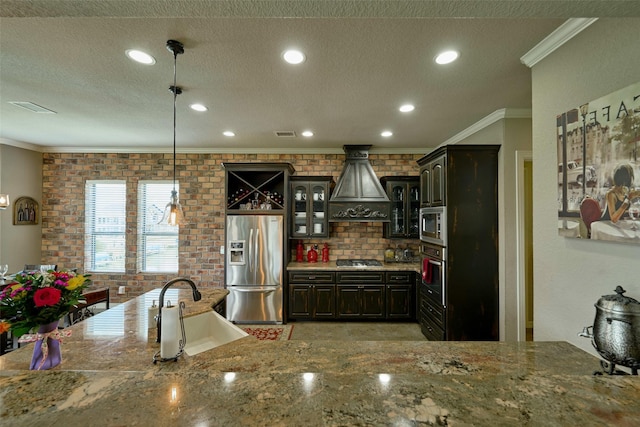 12590 St Ann Ct, Willis, TX 77318 - kitchen with appliances with stainless steel finishes, a sink, custom exhaust hood, ornamental molding, and glass insert cabinets