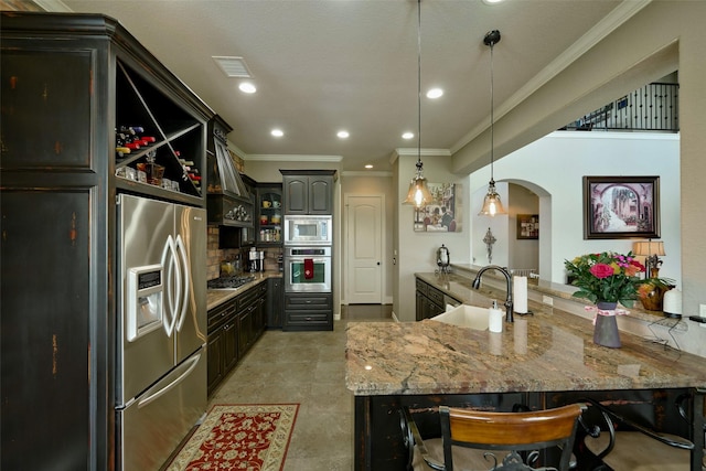 12590 St Ann Ct, Willis, TX 77318 - kitchen with stainless steel appliances, ornamental molding, custom range hood, light stone counters, and a peninsula