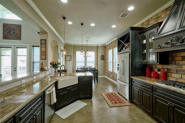12590 St Ann Ct, Willis, TX 77318 - kitchen featuring a sink, ornamental molding, appliances with stainless steel finishes, recessed lighting, and arched walkways