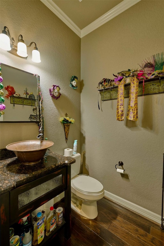 12590 St Ann Ct, Willis, TX 77318 - bathroom with ornamental molding, wood finished floors, toilet, vanity, and baseboards