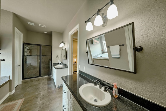 12590 St Ann Ct, Willis, TX 77318 - bathroom featuring a stall shower, two vanities, a garden tub, and baseboards