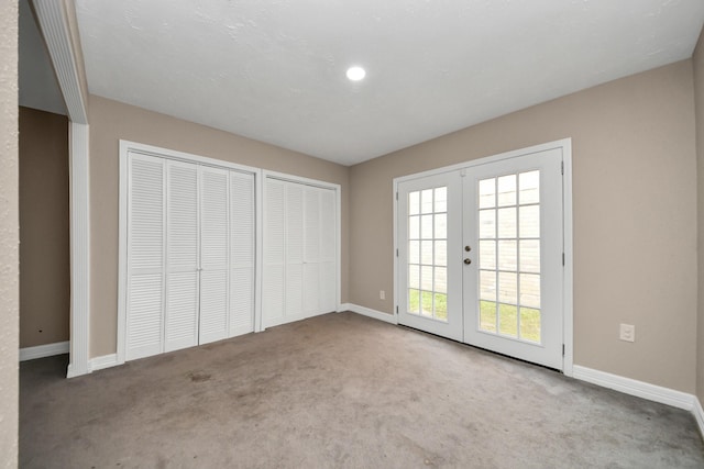 2026 Hickory Glen Dr, Missouri City, TX 77489 - unfurnished bedroom featuring french doors, carpet floors, baseboards, and two closets