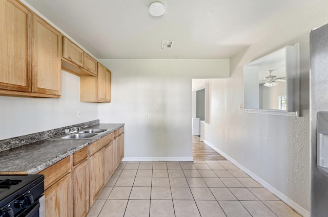 4637 Carmen St, Houston, TX 77051 - kitchen with a sink, light tile patterned floors, ceiling fan, baseboards, and black gas stove