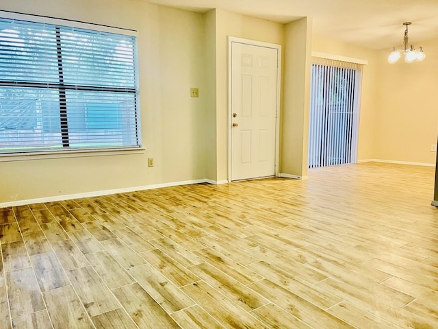 2711 Grants Lake Blvd Unit 203, Sugar Land, TX 77479 - unfurnished room with wood finished floors, a chandelier, and baseboards