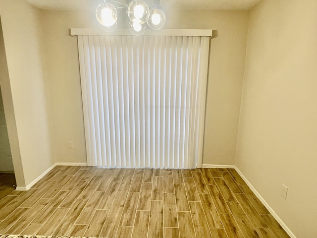 2711 Grants Lake Blvd Unit 203, Sugar Land, TX 77479 - unfurnished dining area with wood finished floors, baseboards, and a chandelier