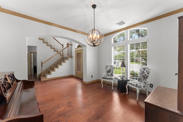 living area featuring ornamental molding, stairway, arched walkways, a chandelier, and hardwood / wood-style floors