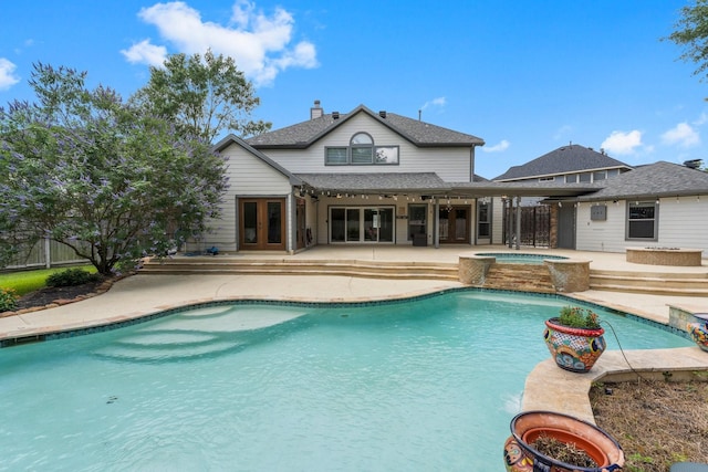 outdoor pool with french doors, an in-ground hot tub, a patio, and fence