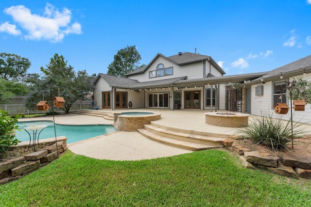back of property featuring french doors, a fire pit, a patio, fence, and a pool with connected hot tub
