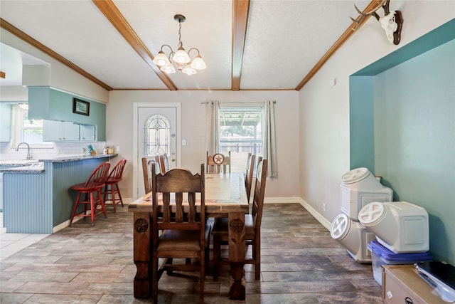 dining area featuring lofted ceiling, ornamental molding, dark wood-style flooring, and a chandelier