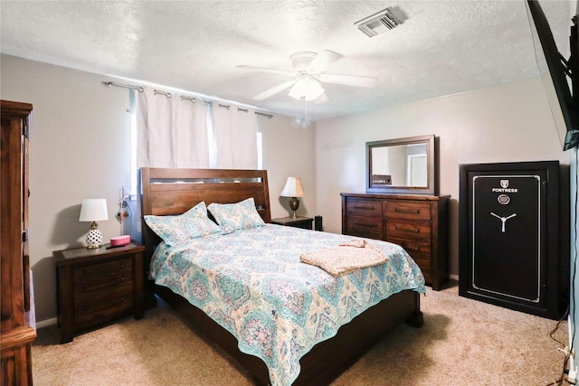 carpeted bedroom featuring a textured ceiling and a ceiling fan